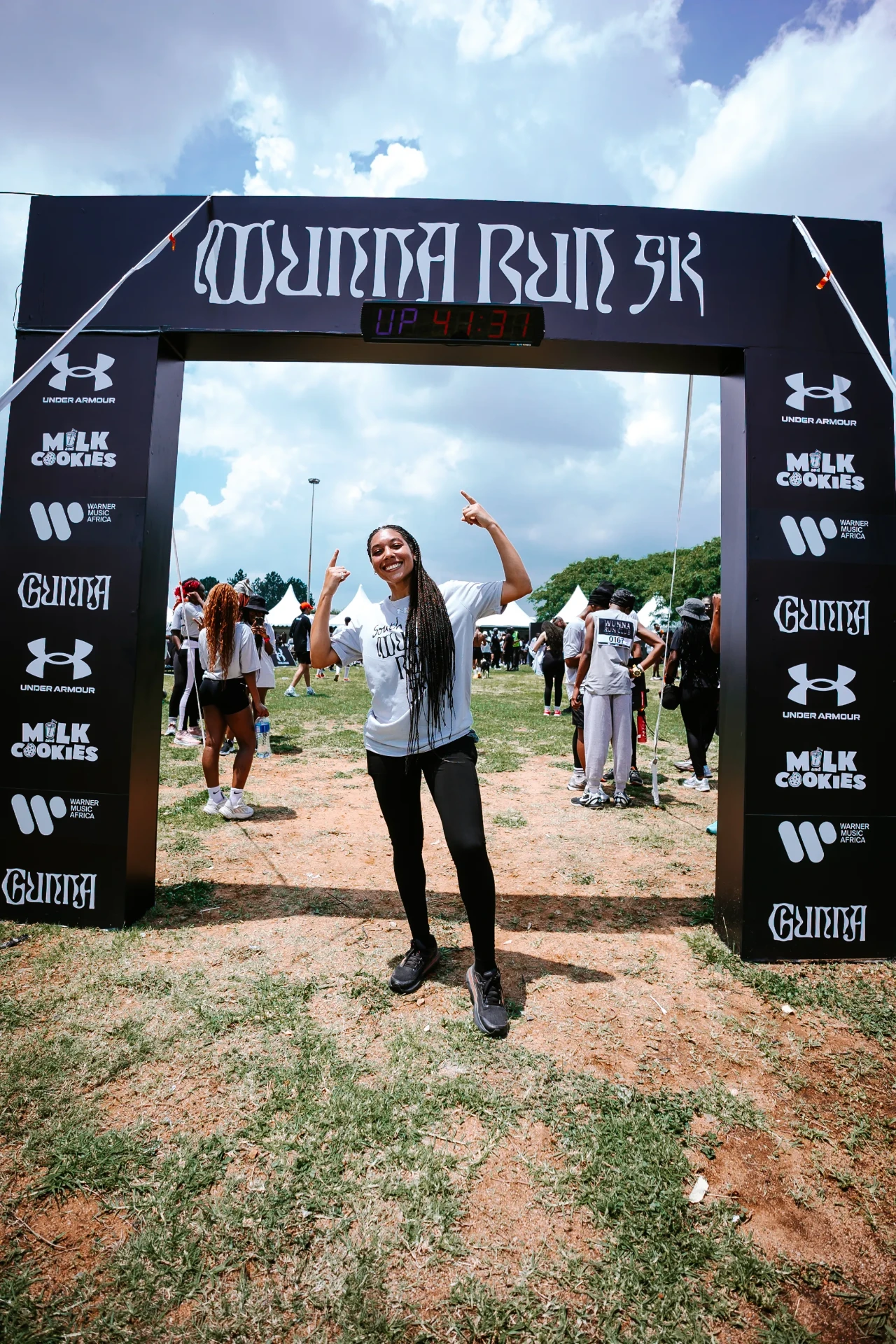 Woman beneath a branded race arch at an outdoor event