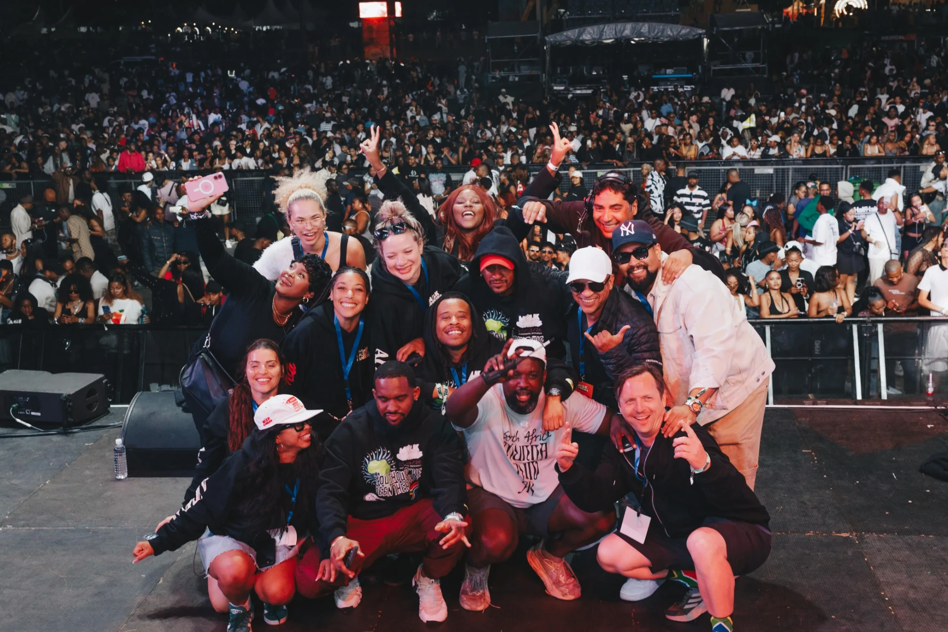 Milk + Cookies team posing in front of a concert crowd